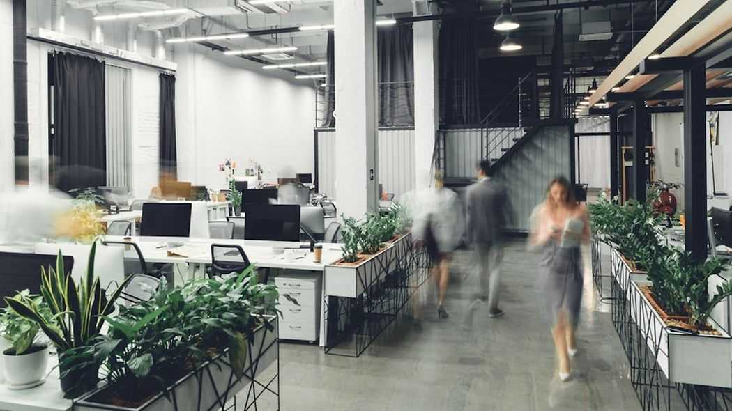 Open plan office flow with visually blurred people walking around.